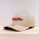Beige cap with red logo on a light wooden surface