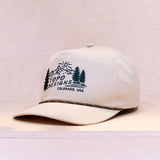 White cap with Topo Designs logo on a light gray background